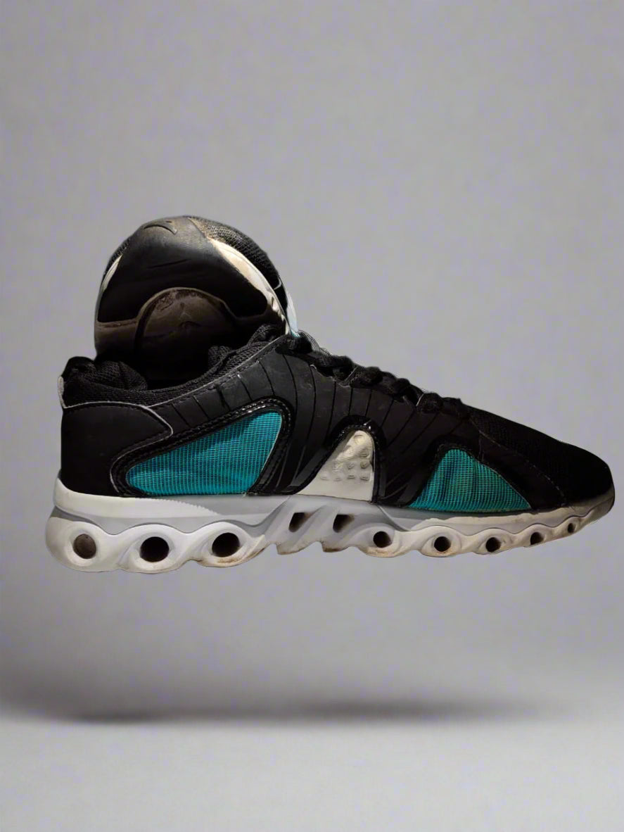 Black and blue sneaker on a white platform with a dark background