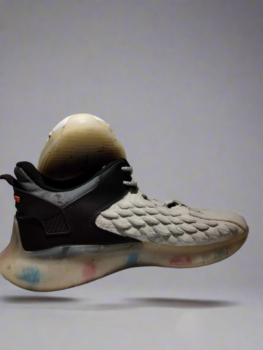 Gray and black sneaker with textured design on a gray background