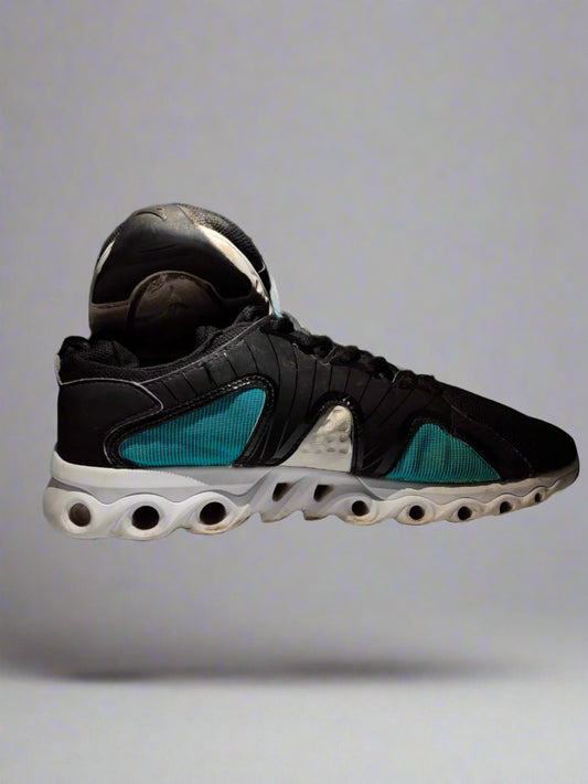 Black and blue sneaker on a white platform with a dark background