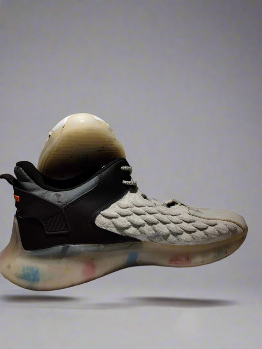 Gray and black sneaker with textured design on a gray background