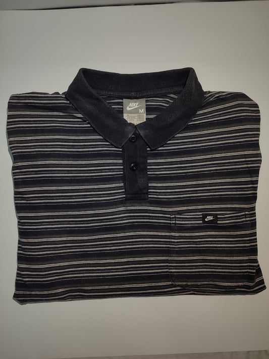Folded black and gray striped polo shirt with Nike logo on a white background